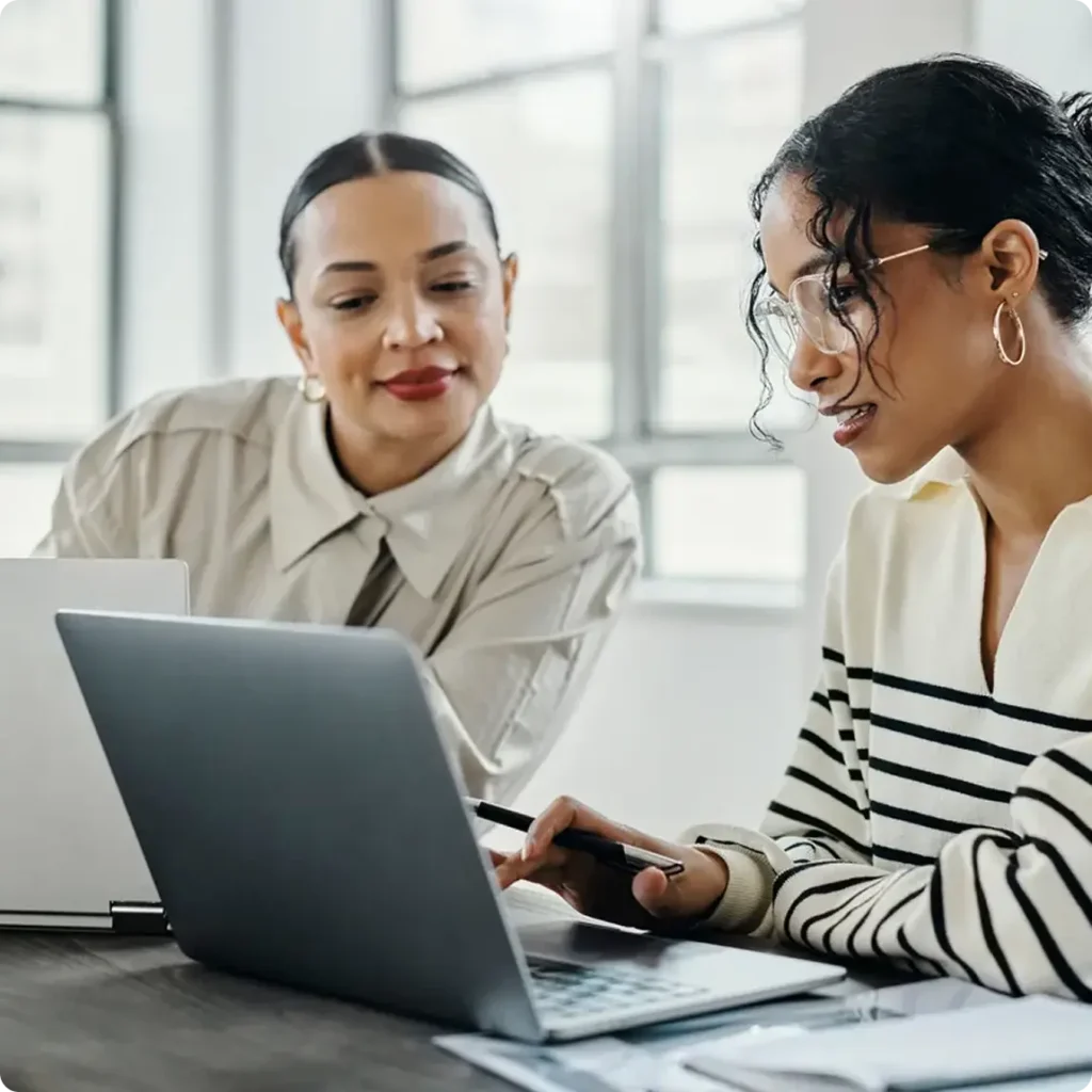 Two women focused on a laptop