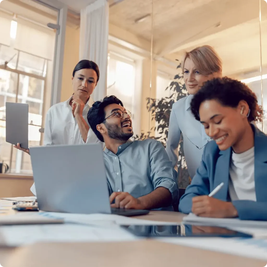 A team of individuals focused on a laptop