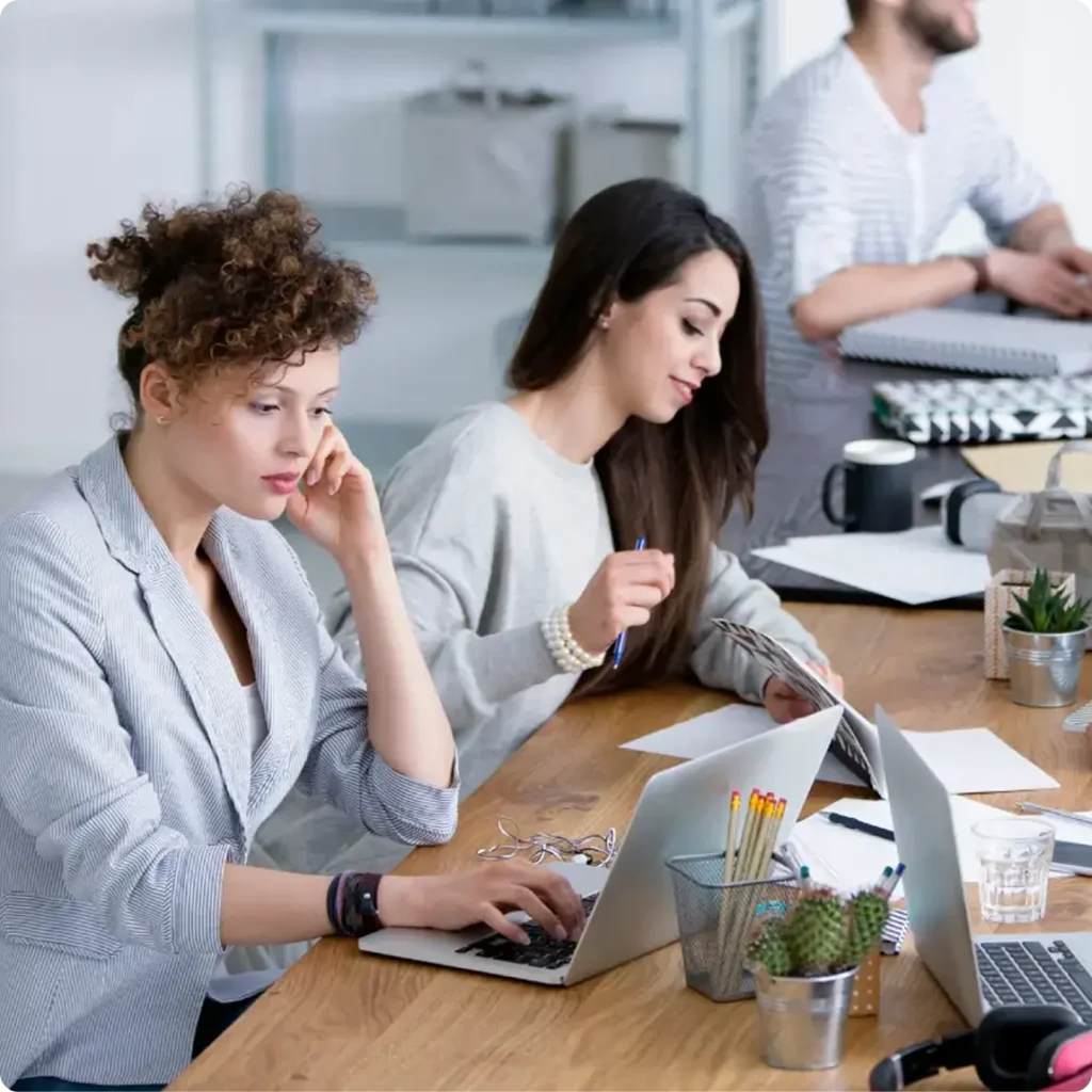 Two women focused on their laptops