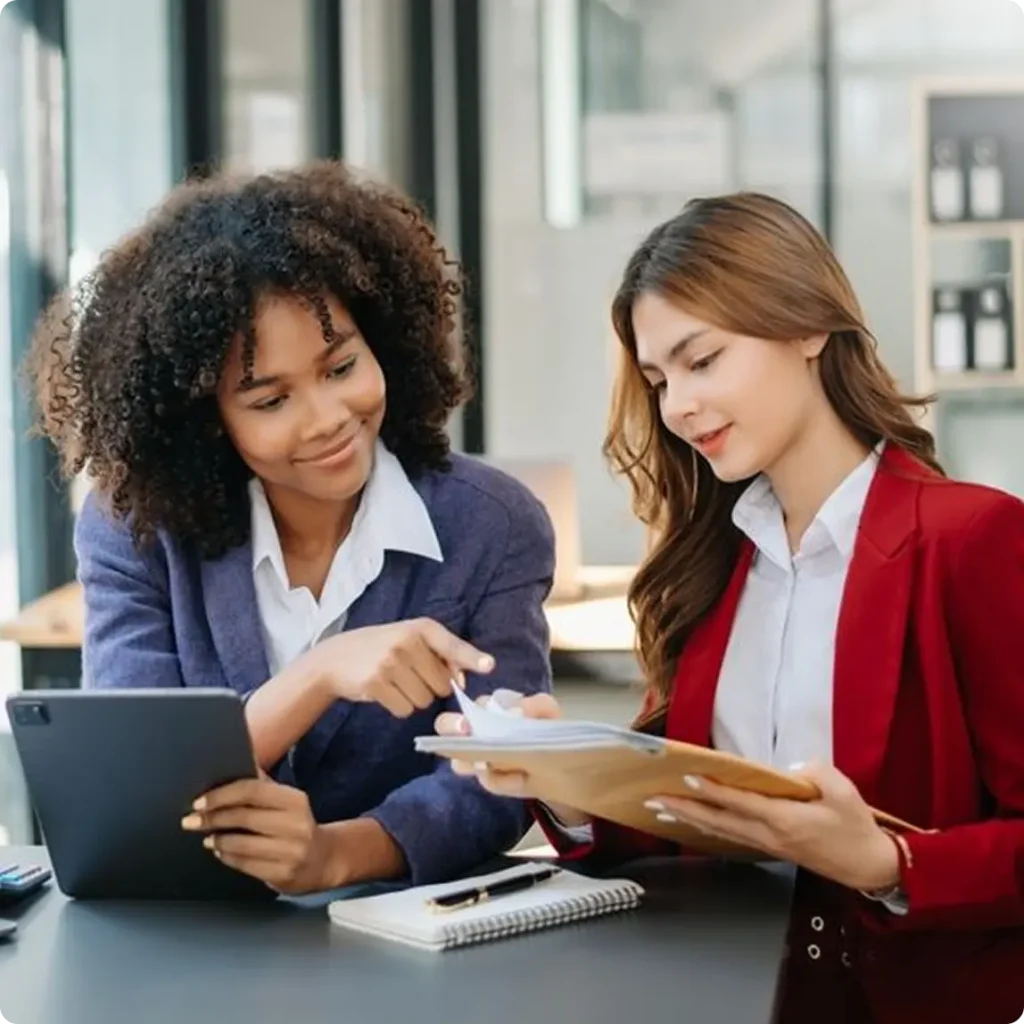 Two businesswomen in suits collaborate