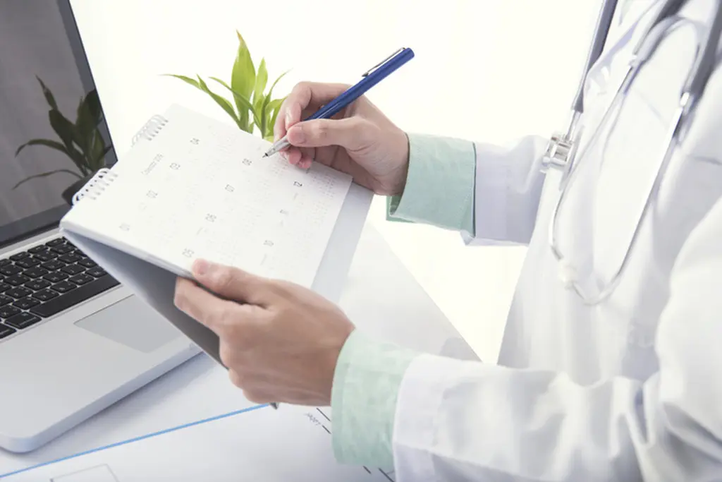 A doctor is writing notes on a calendar